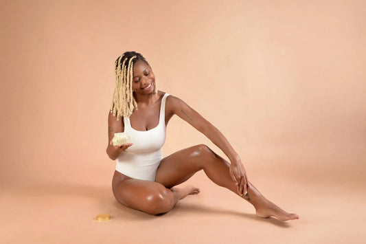 A woman in a white bodysuit applying Nurture by Nuri