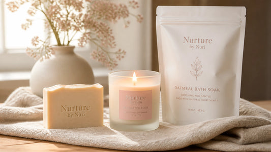 A serene spa-like arrangement featuring a creamy Nurture by Nuri handmade soap bar, a softly glowing Alabaster Rose candle, a